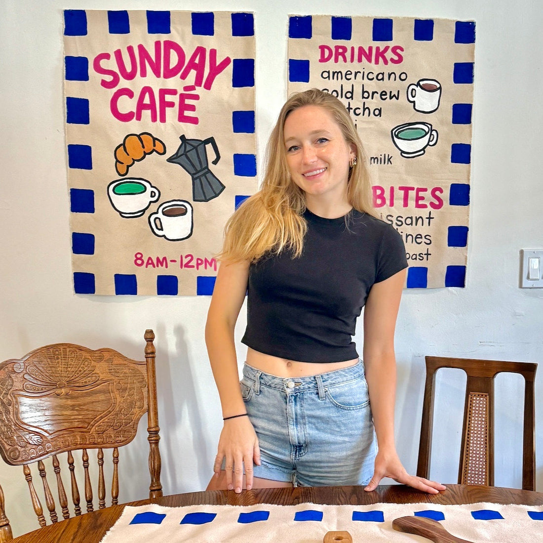 Painted banner with coffee shop motifs and young girl crafting it