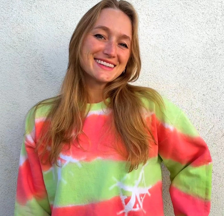 girl wearing a tie dye red and green holiday sweater